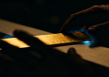 Mains manipulant une barre d'or.