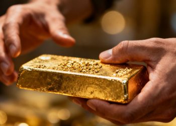 Main d'or tenant une barre d'or
