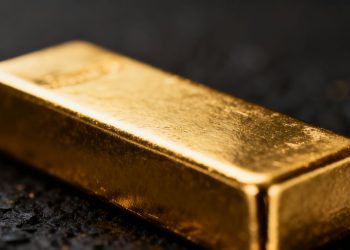 Lingot d'or brillant sur fond sombre.