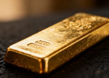 Lingot d'or brillant sur fond sombre.