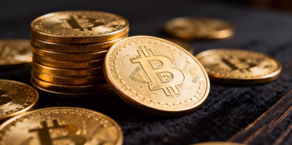 Pièces d'or d'investissement brillantes empilées et dispersées.