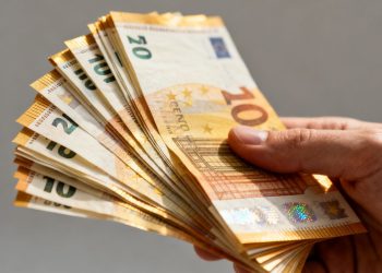 A mão de um especialista segurando notas de euro.