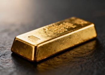 Lingot d'or brillant sur fond sombre.