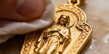 Reinigung eines goldenen religiösen Anhängers.