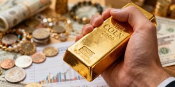 金手拿著金條，背景是各種金融資產。
