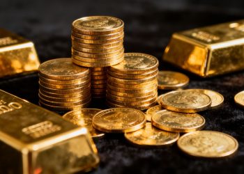 سبائك وعملات ذهبية لامعة مكدسة.