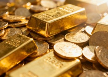 Lingots et pièces d'or brillants sous la lumière.