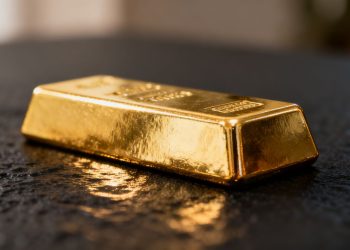 Lingot d'or brillant sur fond sombre.