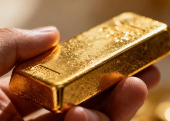 Main d'or tenant une barre d'or