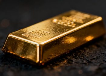 Barra de oro brillante sobre fondo oscuro.