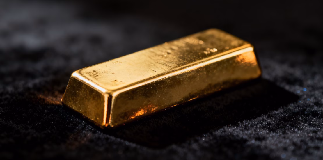 Lingot d'or brillant sur fond sombre.