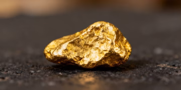 Nugget d'or brillant sur fond sombre.