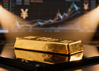 Lingote de oro con el mercado financiero como telón de fondo.