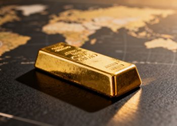 سبيكة ذهبية على خلفية داكنة مع خريطة عالمية ضبابية.